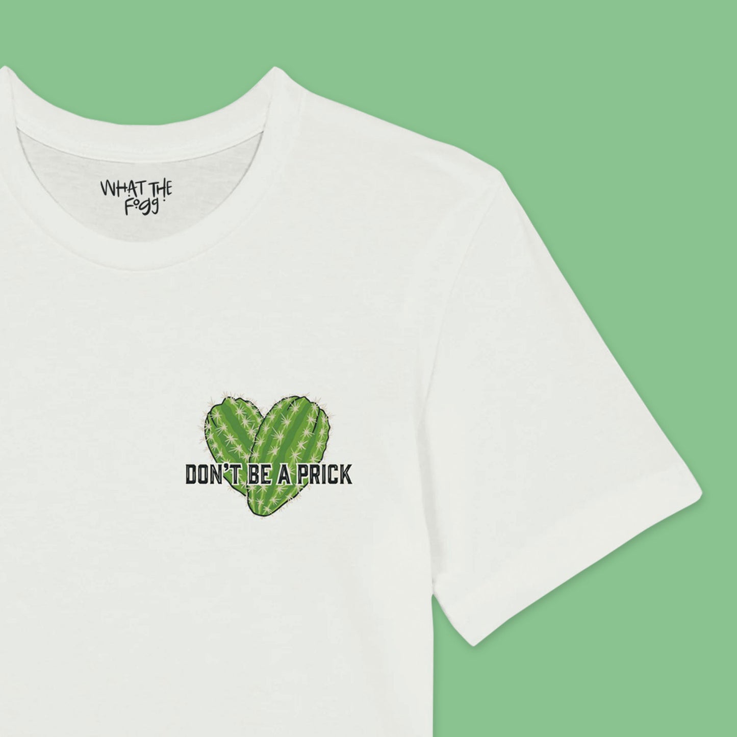 Close up of a White t-shirt featuring a chest badge with an illustration that reads 'Don't Be a Prick.' The design includes two cactuses arranged in the shape of a heart behind the text."