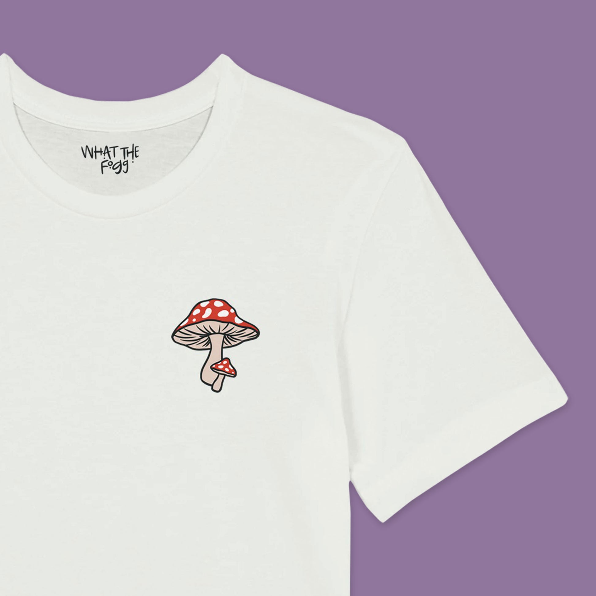 Close up of White T-shirt with red mushroom printed in front left chest area.