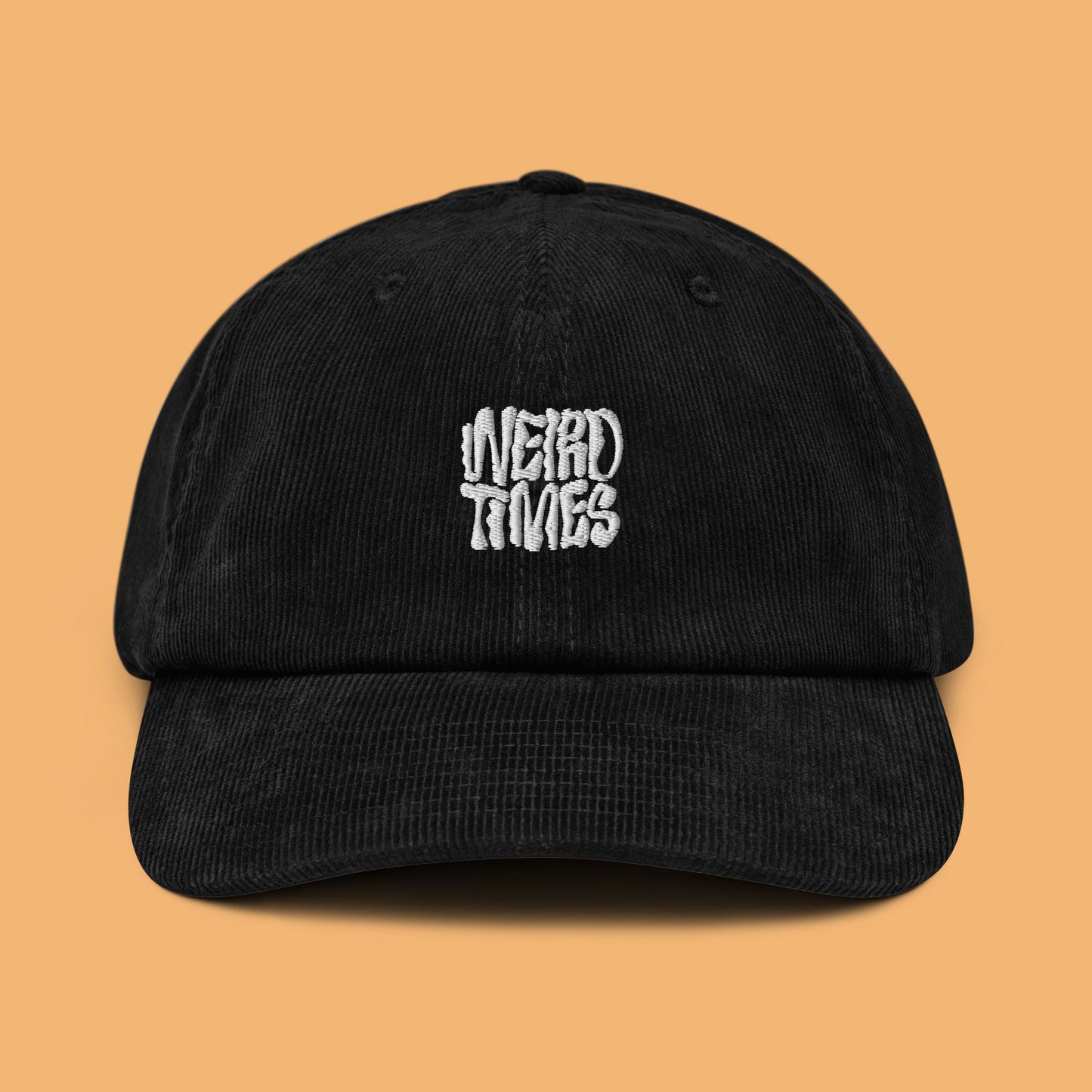 Front angle of a black corduroy hat with 'Weird Times' printed in white on the front.