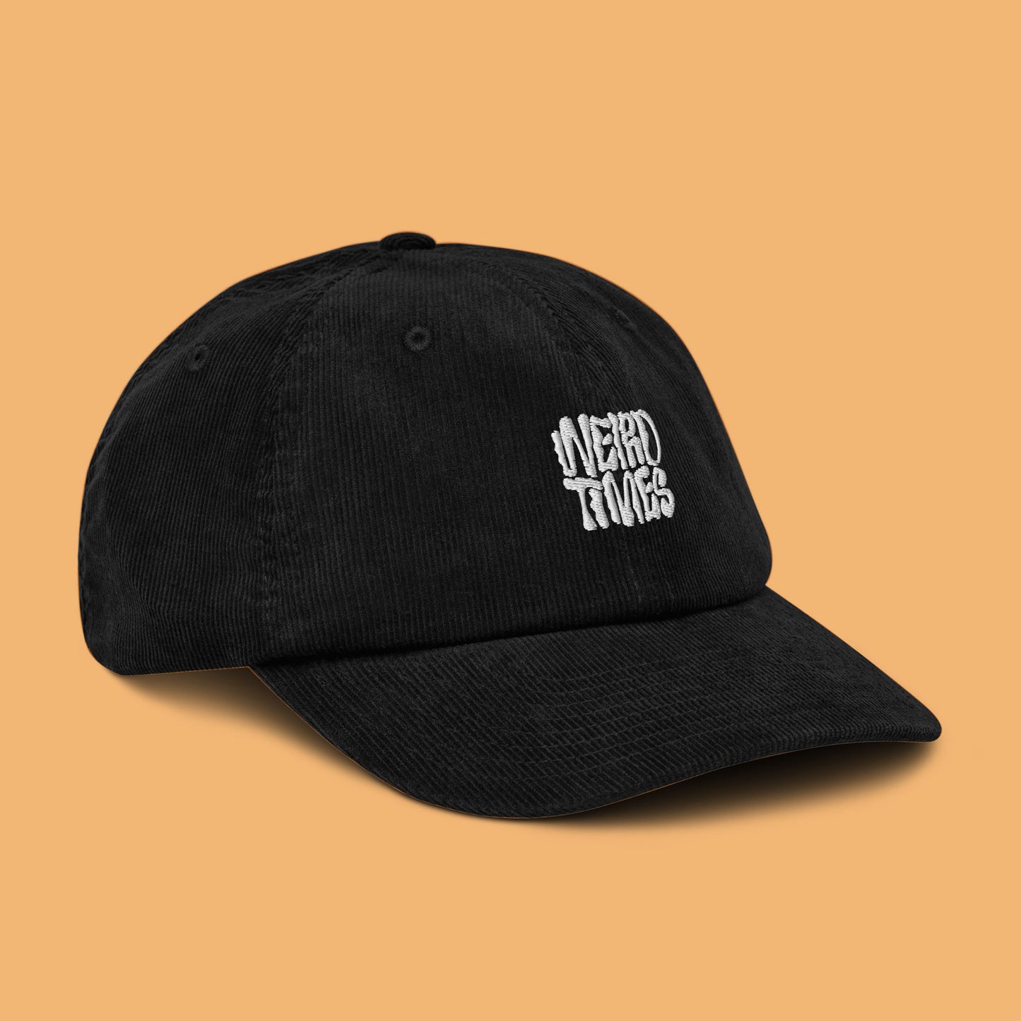 Front-side angle of a black corduroy hat with 'Weird Times' printed in white on the front.