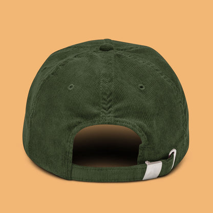 Back-angle view of a dark olive-coloured corduroy hat with 'Weird Times' printed in white on the front.