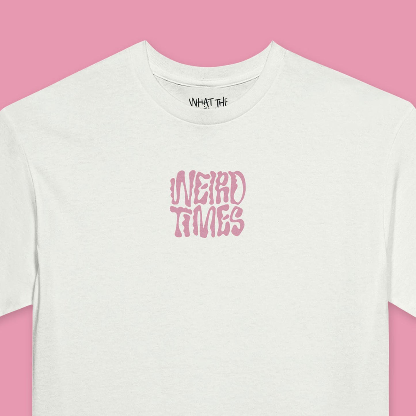 Close up of White T-shirt with 'Weird Times' printed in pink in the centre of the front.