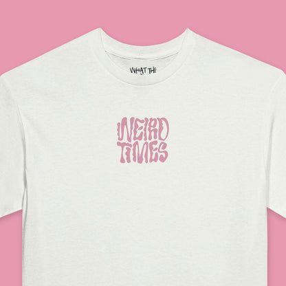 Close up of White T-shirt with 'Weird Times' printed in pink in the centre of the front.
